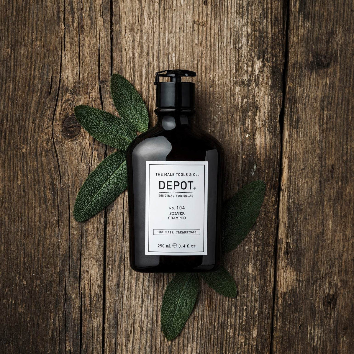 Depot No. 104 Silver Shampoo 250ml flaske på trebord med salvieblader.