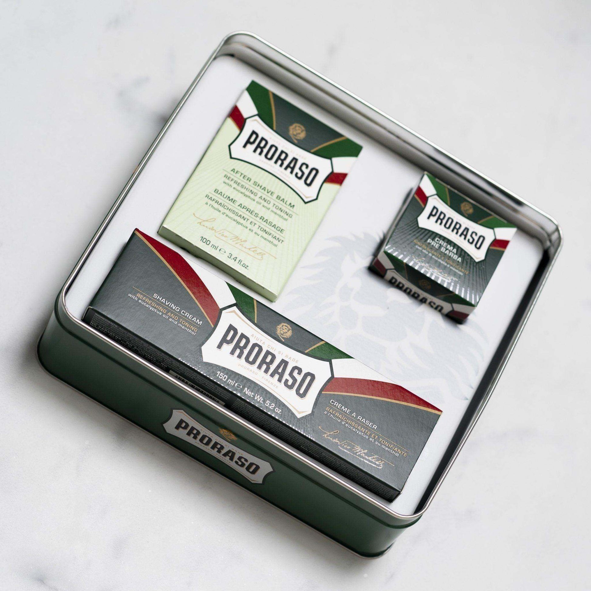Proraso gift set with shaving products in a tin, including pre shave cream, shaving cream, and aftershave balm.
