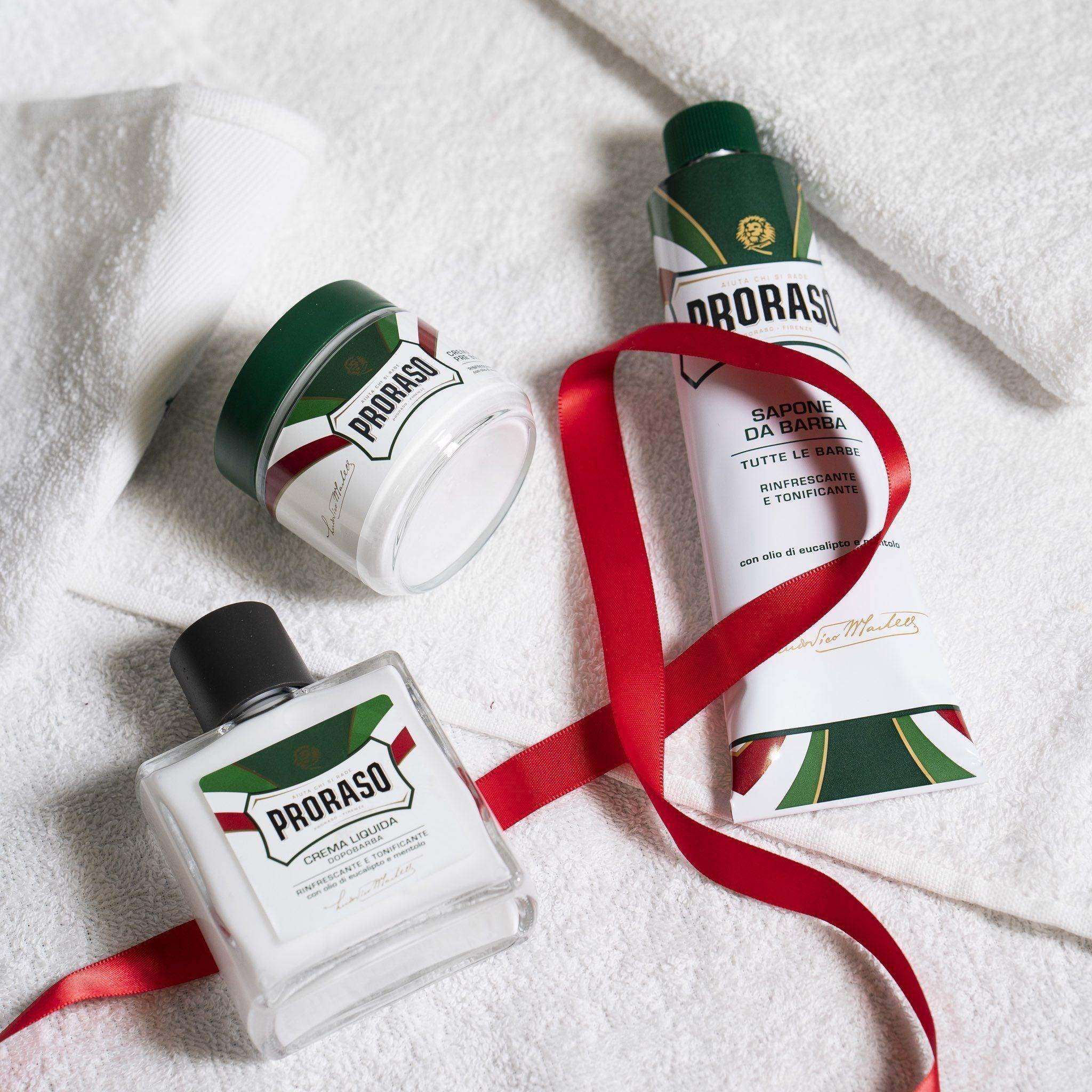 Proraso shaving gift set with pre shave cream, shaving cream, and aftershave cream on white towels.